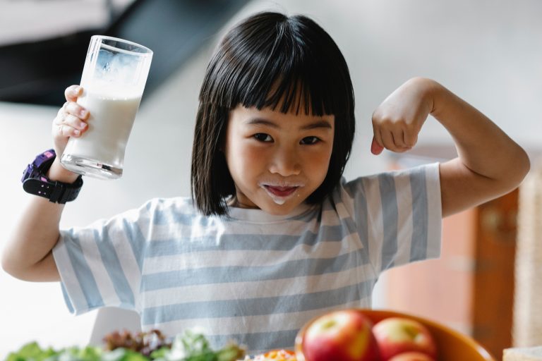 anak perempuan meminum segelas susu