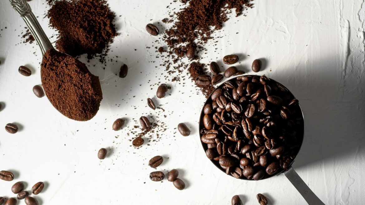 secangkir kopi, sesendok kopi bubuk, sewadah bijih kopi, botol kaca berisi kopi bubuk jatuh di atas meja, high angle shoot