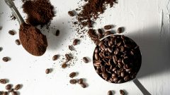 secangkir kopi, sesendok kopi bubuk, sewadah bijih kopi, botol kaca berisi kopi bubuk jatuh di atas meja, high angle shoot