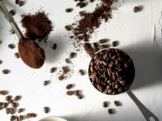 secangkir kopi, sesendok kopi bubuk, sewadah bijih kopi, botol kaca berisi kopi bubuk jatuh di atas meja, high angle shoot