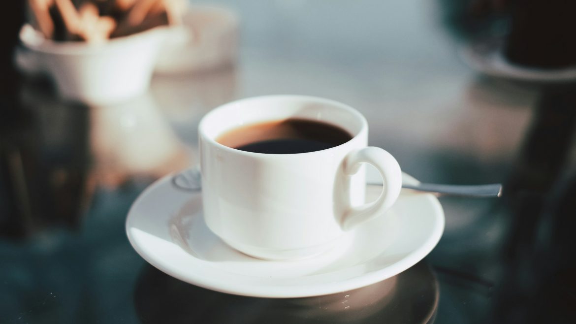 secangkir kopi hitam di atas meja kaca