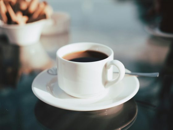 secangkir kopi hitam di atas meja kaca